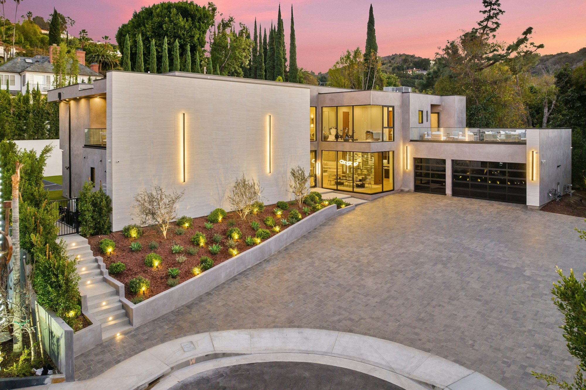Contemporary residence features a spacious driveway that gracefully ascends to the upper floor